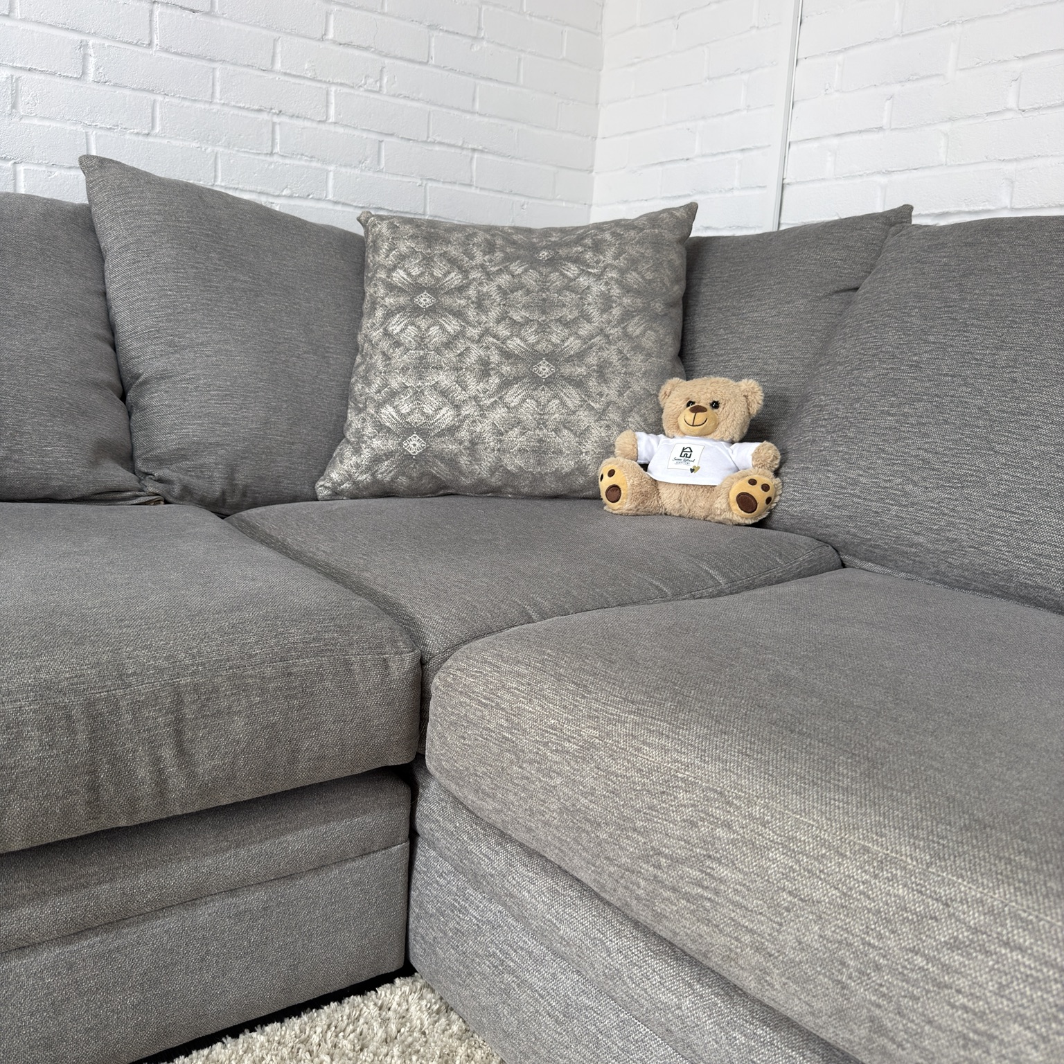 Close-up of the grey sofa's pillow back and foam-filled seat cushions